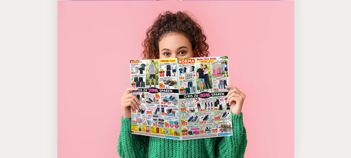Eine Kundin blickt in einen NORMA Prospekt. Klicken Sie, um den für Sie gültigen Prospekt durch Auswahl einer Filiale zu bestimmen.